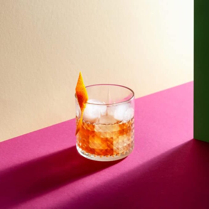 Glass with Whiskey and Ice Cube on Table with Hard Shadows. Modern Isometric Style. Creative Concept.